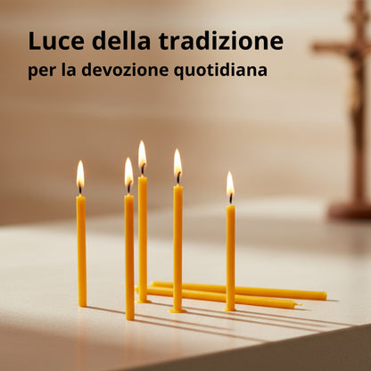 Candele sottili gialle accese su un tavolo, con una croce sullo sfondo