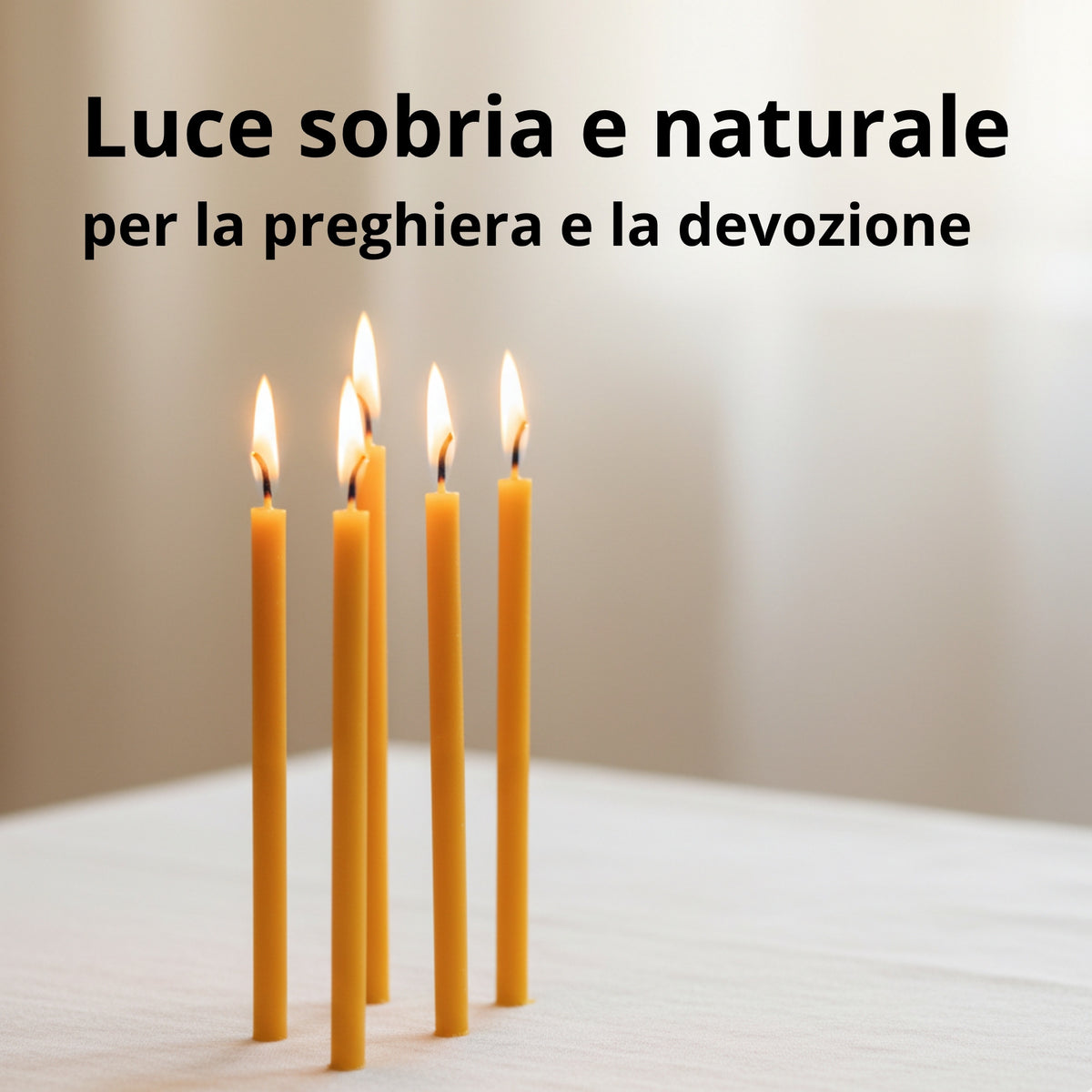 Quattro candele sottili gialle accese su un tavolo chiaro