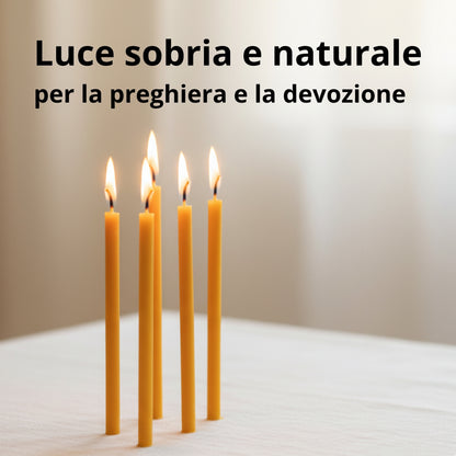 Quattro candele sottili gialle accese su un tavolo chiaro