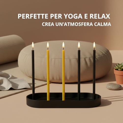 Quattro candele sottili accese, nere e gialle, su un supporto nero, con un cuscino sullo sfondo e testo «Perfette per yoga e relax»