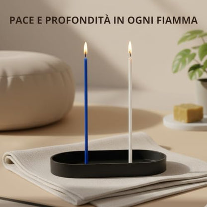 Una candela blu e una bianca accese su un supporto nero ovale, con testo «Pace e profondità in ogni fiamma»