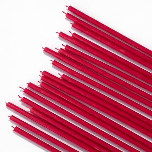 Candele sottili rosse disposte in diagonale su fondo bianco